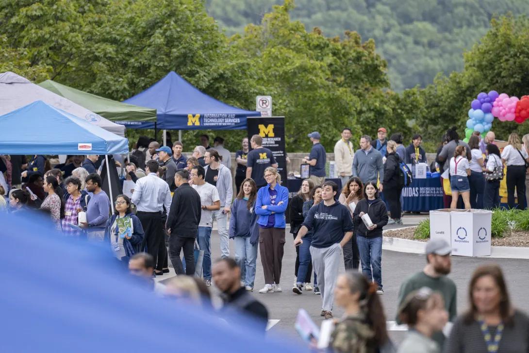 distant picture of people talking and smiling at a tabling event outdoors