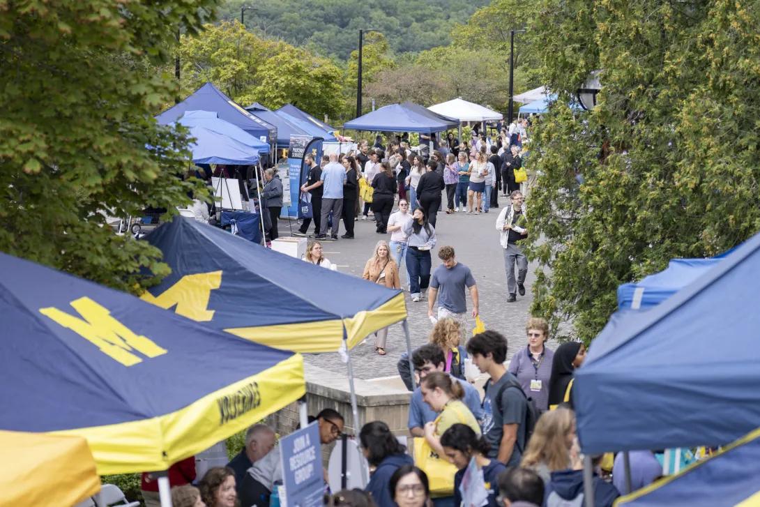distant picture of people talking and smiling at a tabling event outdoors